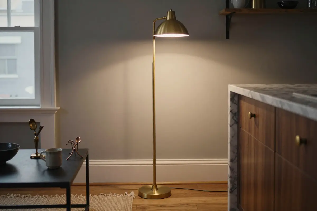 Brass cabinet pulls on a kitchen island echoing a brass floor lamp in the living area